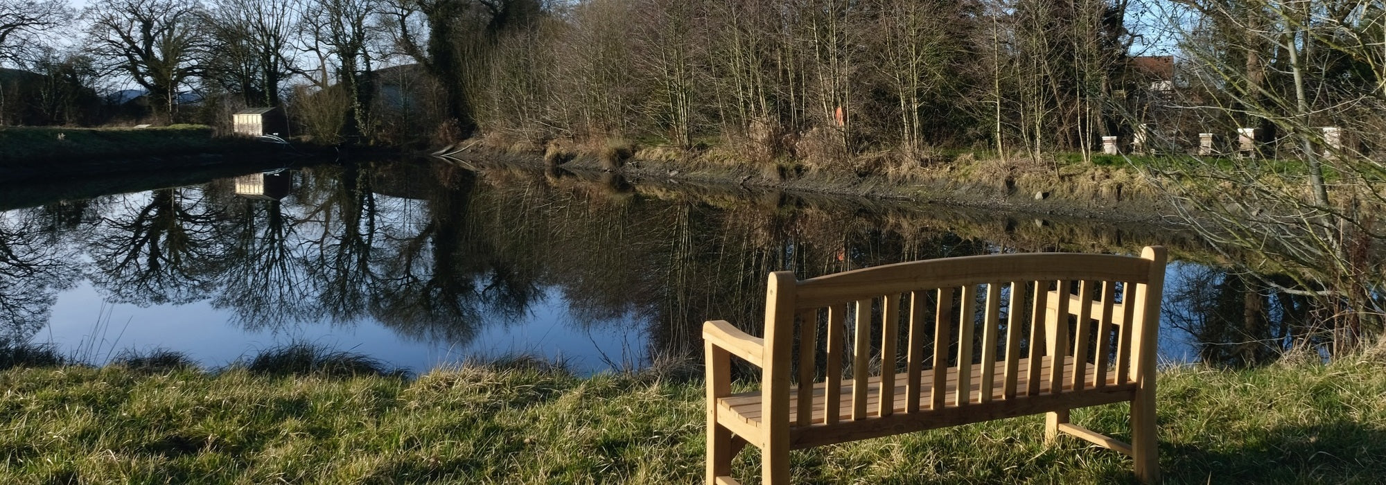 Image of a reservoir at David Austin with a bench over looking the water